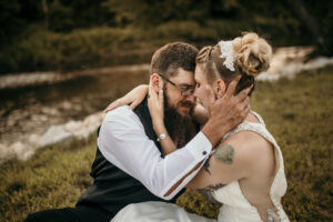bridal couple sitting by the river