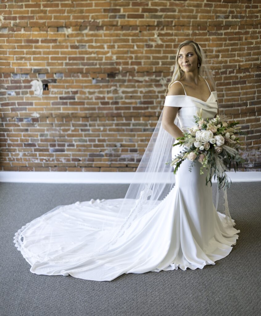 bride weaRING IVORY LACE EDGED VEIL & GOWN