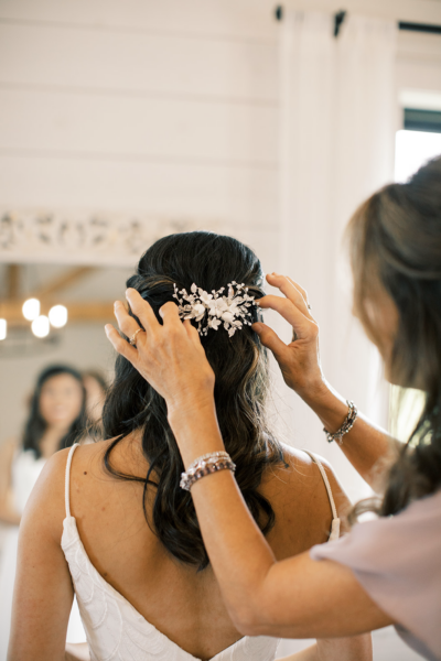mom adjusting her daughters hair clip for her wedding
