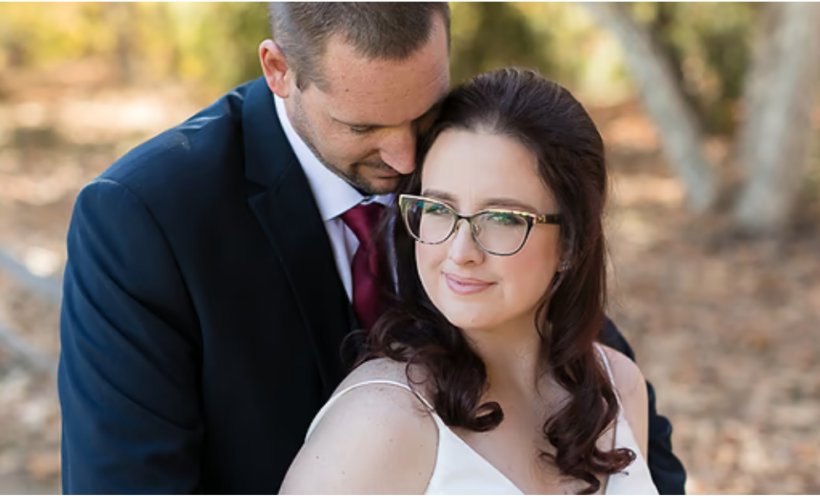 bride wearing glasses posing with her groom