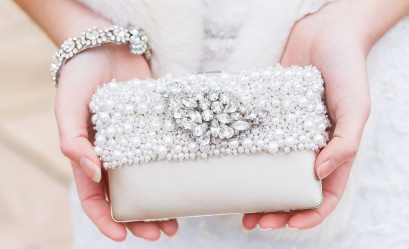 bride holding a satin beaded clutch