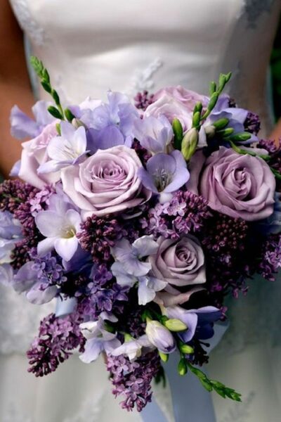 bride holding a bouquet of purple rose