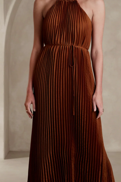 woman wearing a Halter Pleated Maxi Dress in a rust color