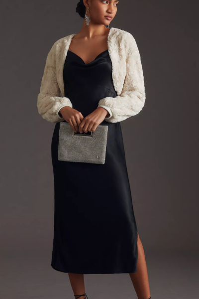 model wearing a black Dres and ivory faux fur shrug
