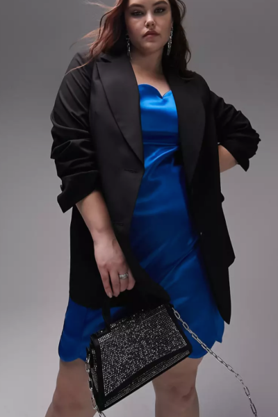 woman wearing black satin blazer with blue slip dress