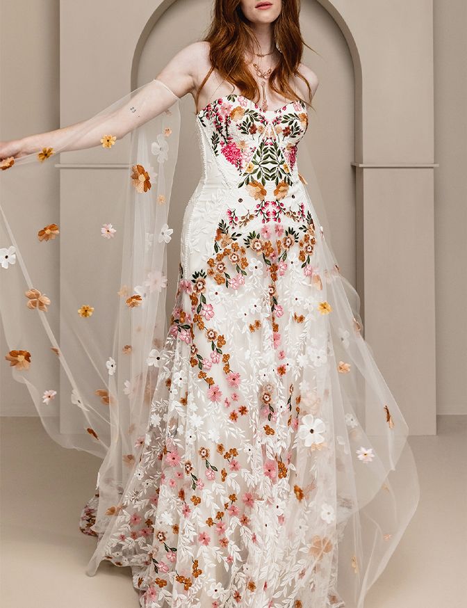 model wearing a Rue de Seines floral gown with cape wind sleeves